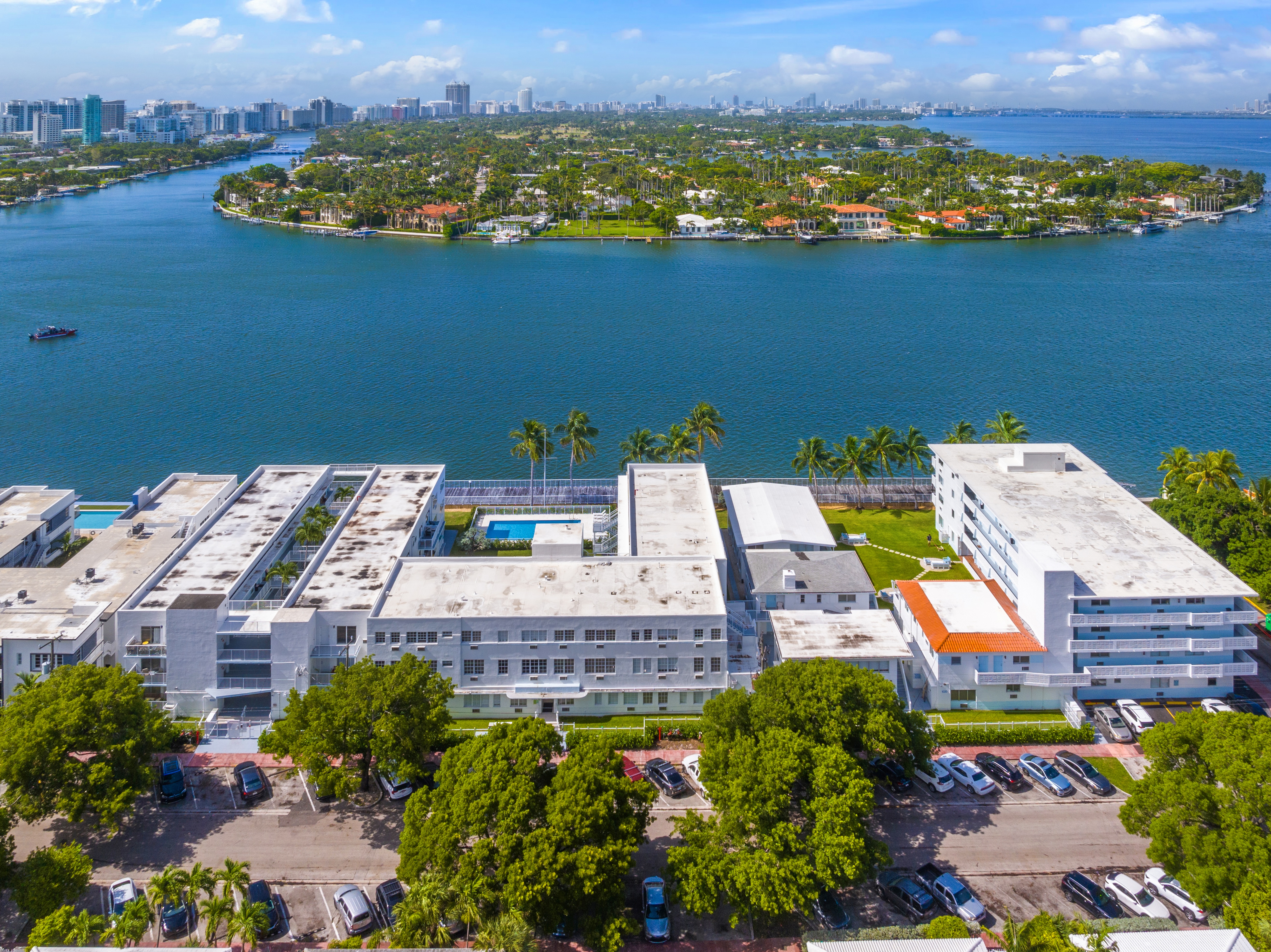 A large white building with a pool in the middle of a parking lot.