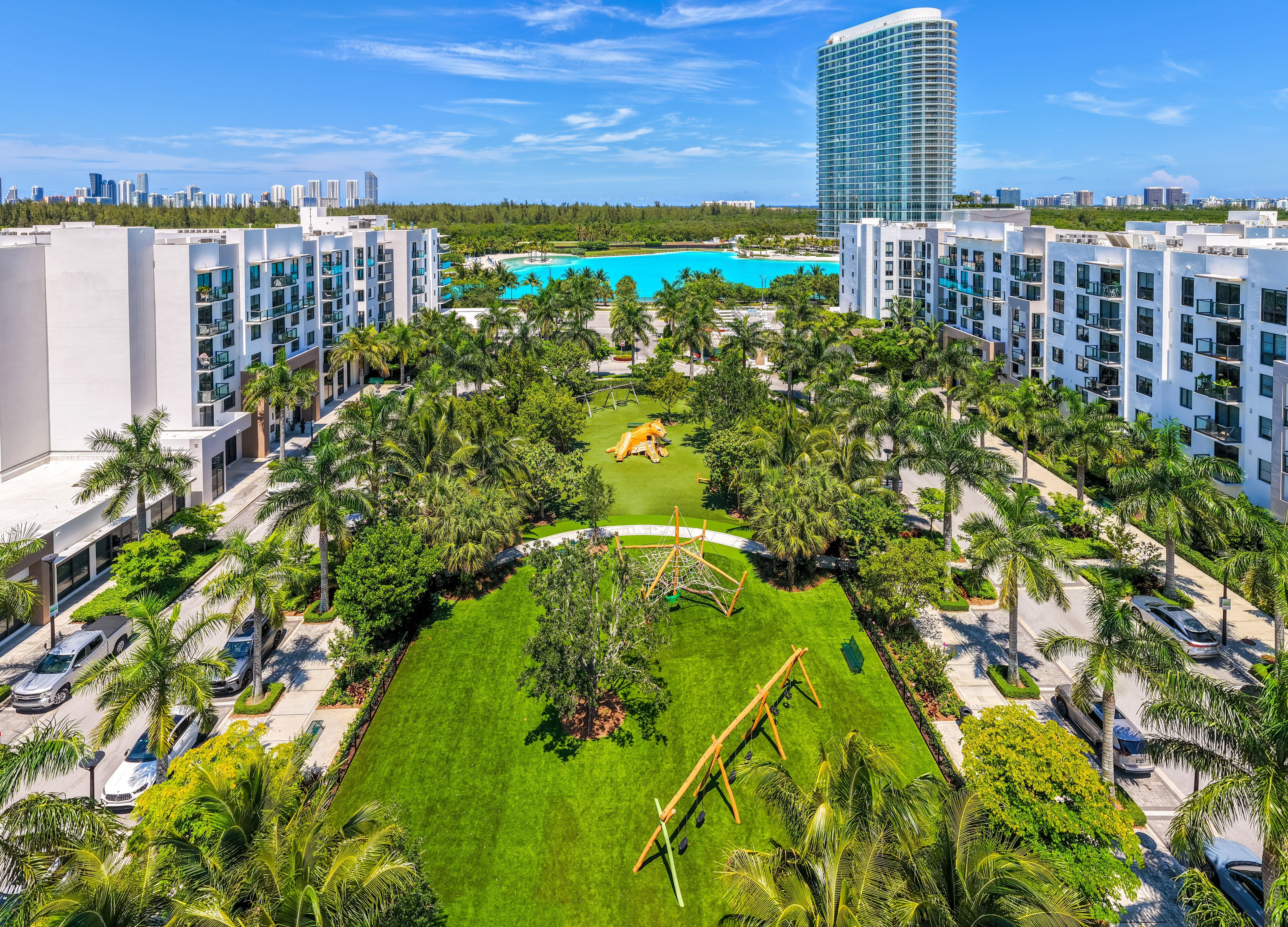 A view of a resort with a pool and palm trees.