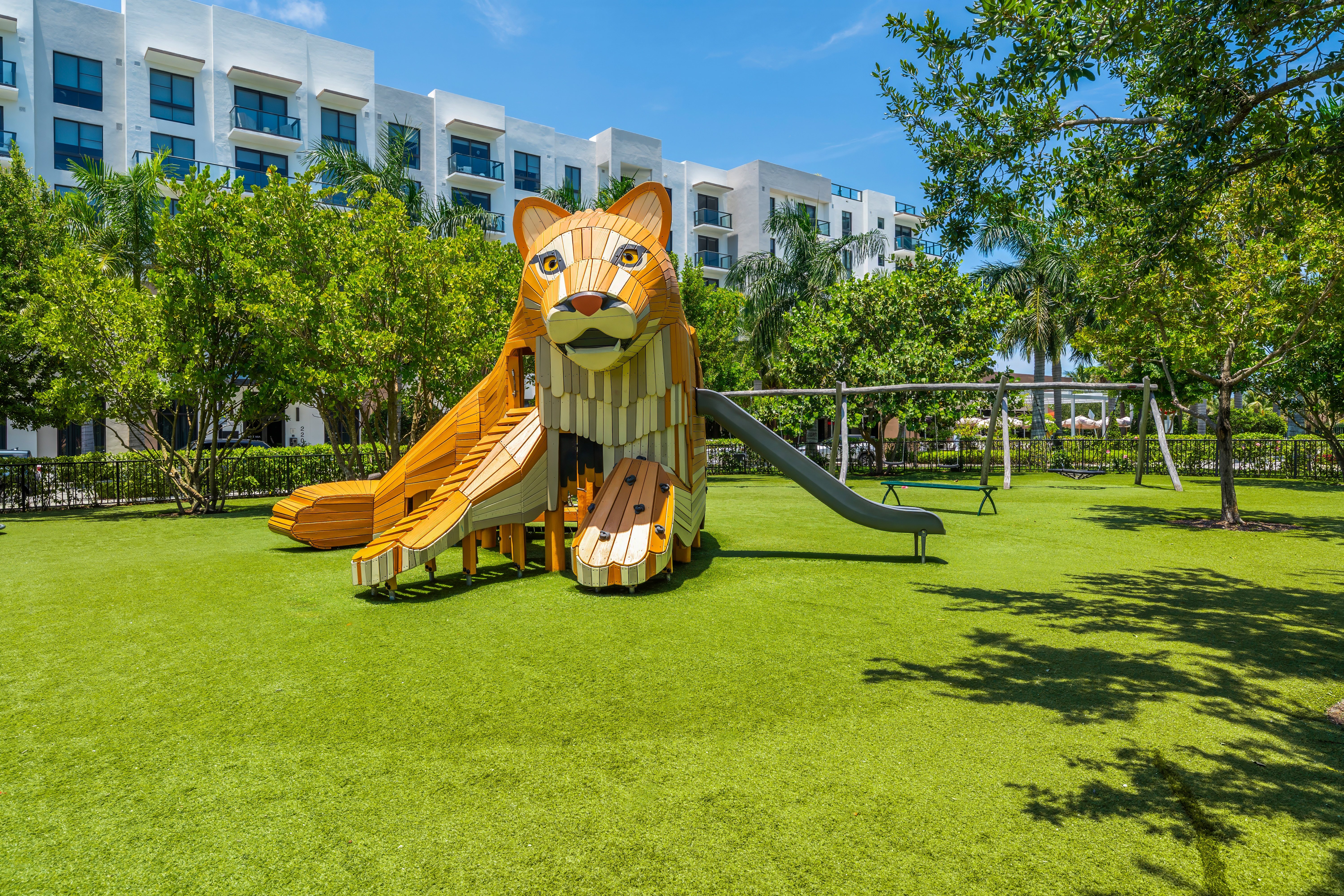 A playground with a slide shaped like a lion's head.