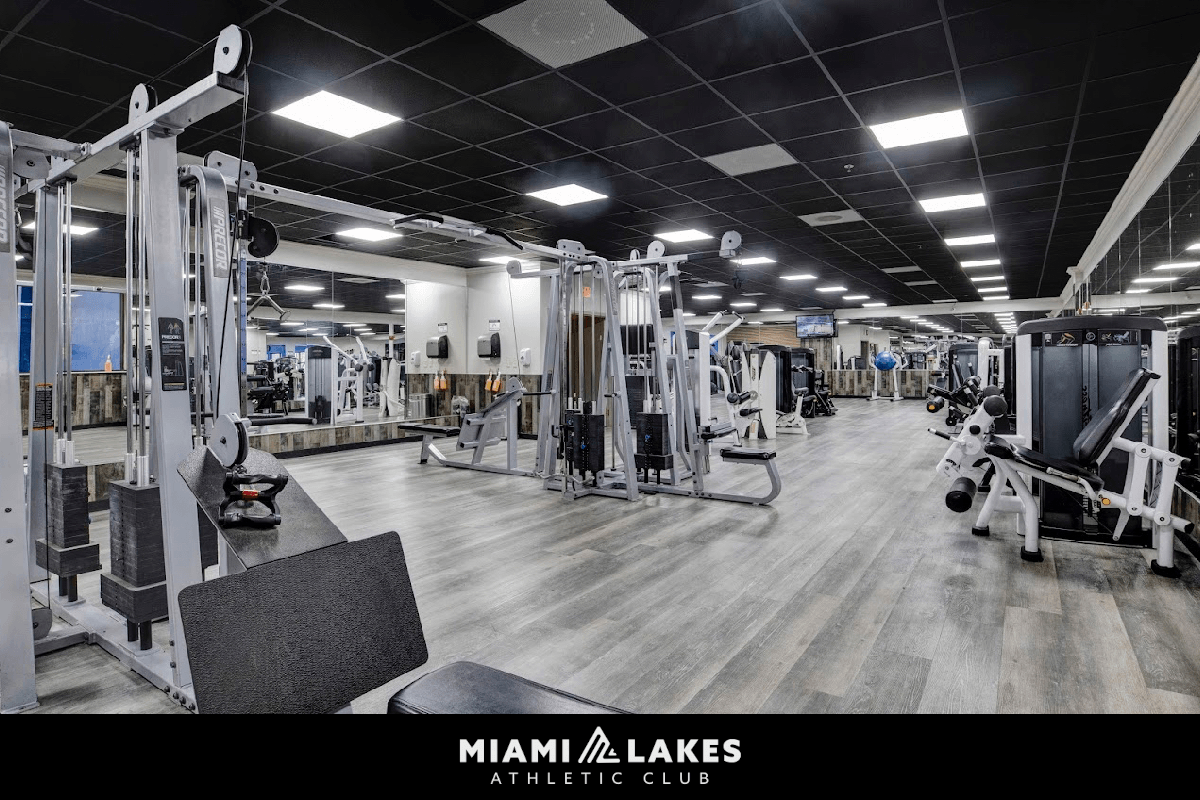 A gym with a variety of equipment inside the Miami Lakes Athletic Club.