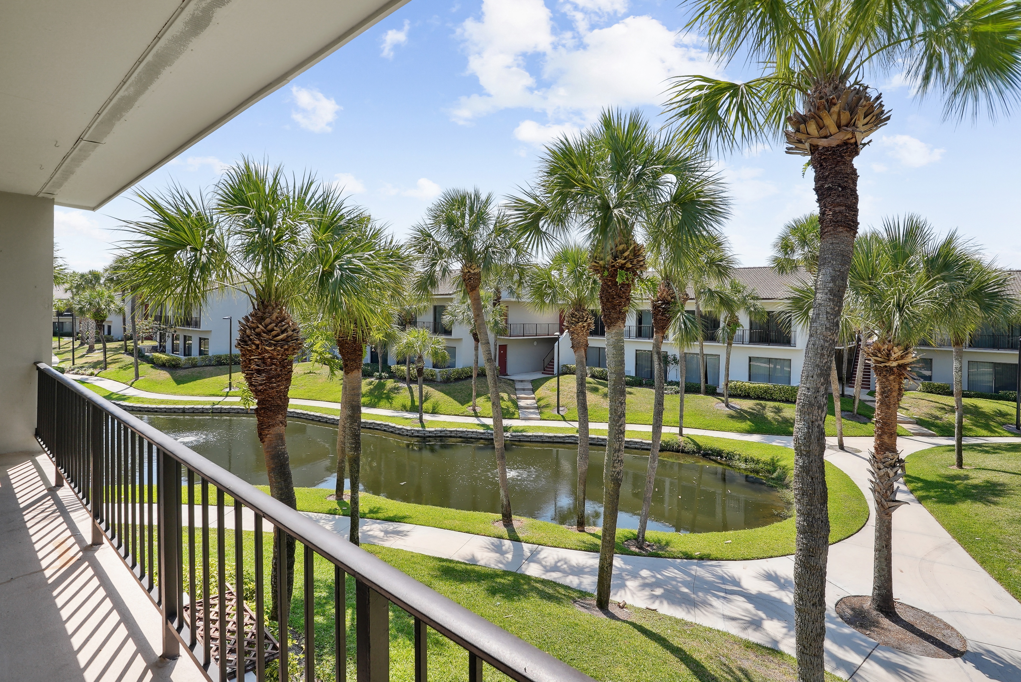 a balcony with a pond and palm trees