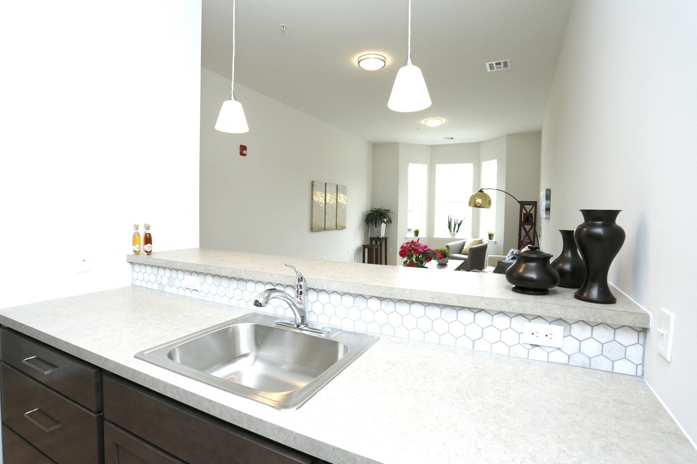 Model kitchen with wooden cabinets and light grey counter top