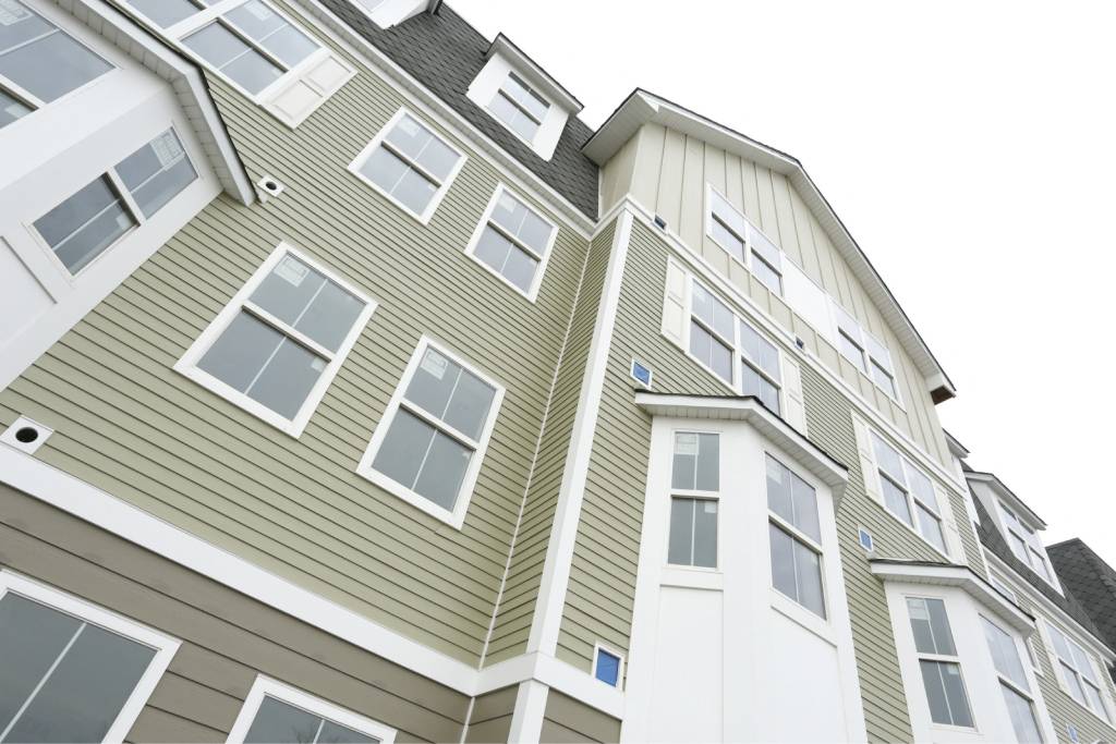 a green and white apartment building with windows