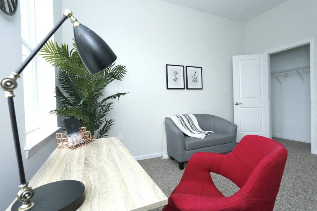 a living room with a red chair and a table