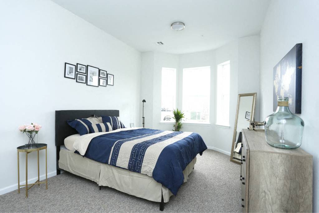 a bedroom with a bed and a large window
