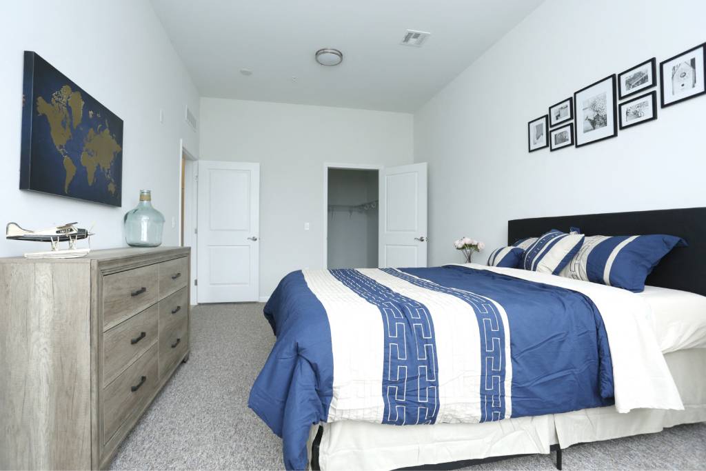 a blue and white bedroom with a bed and a dresser