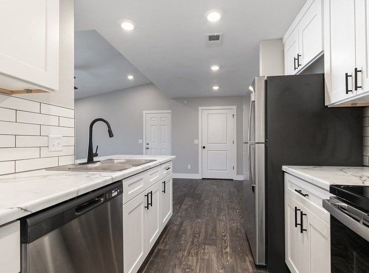 kitchen with white countertops and hardwood floors at Quail Creek Apartments