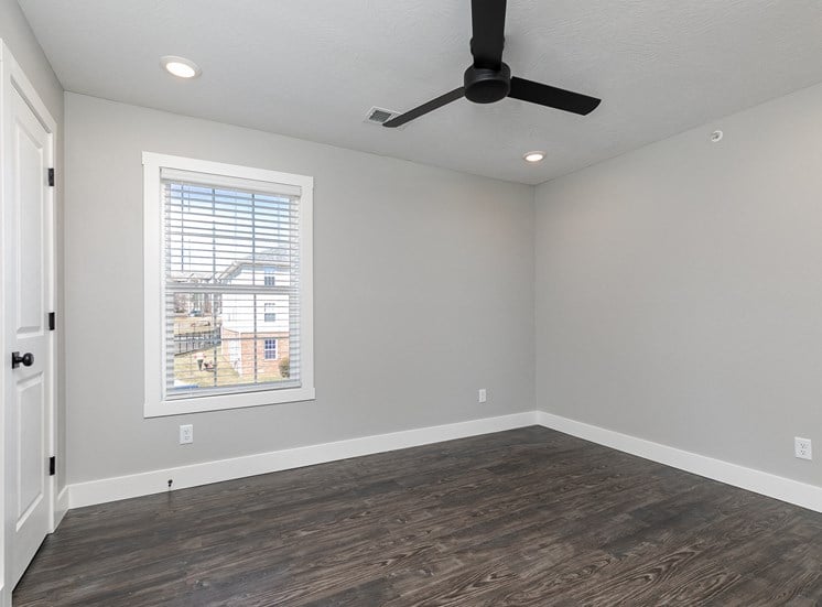 apartment bedroom with hardwood floors and a ceiling fan