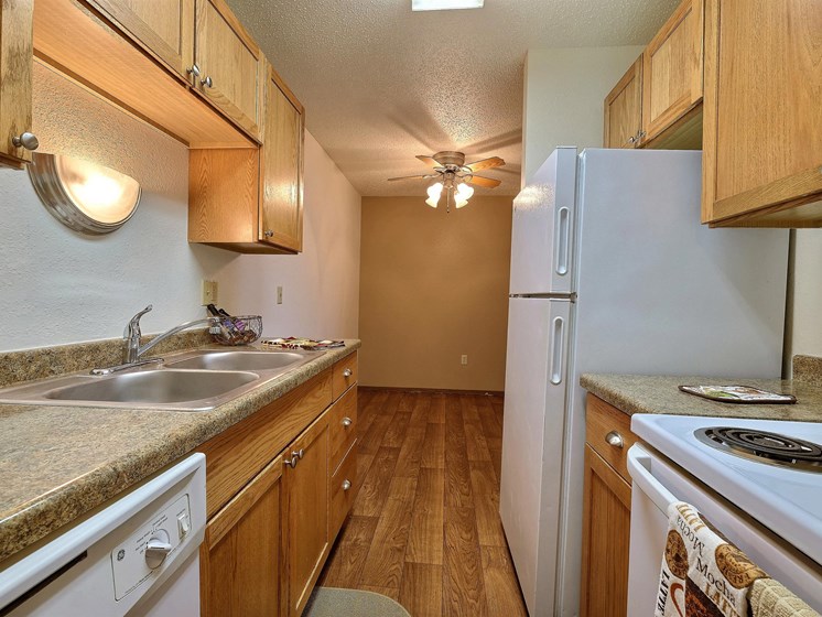 a kitchen with wood floors and white appliances. Fargo, ND Pacific Park Apartments.
