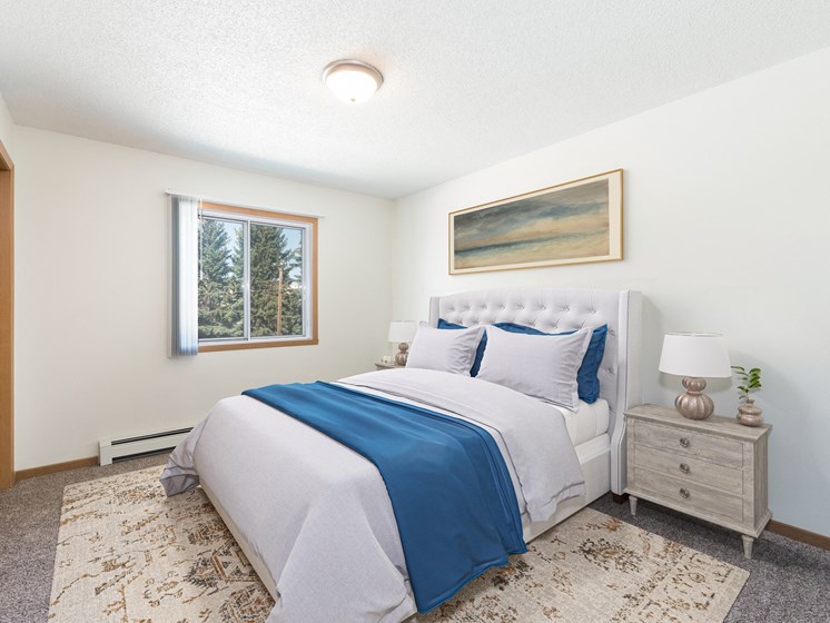 Bismarck, ND Sierra Ridge Apartments The room showcases a peaceful ambiance with a cozy bed, stylish furnishings, and soft lighting from the window