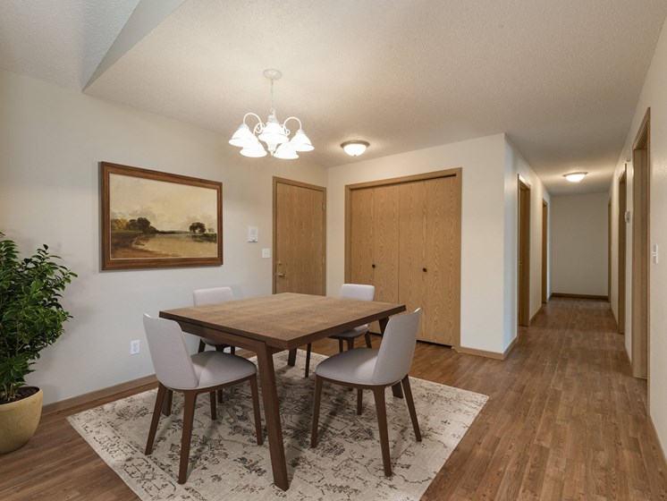 Bismarck, ND Sierra Ridge Apartments. The room showcases a modern dining table with four elegant chairs, well-placed lighting, and a sophisticated ambiance for enjoyable meals and gatherings.
