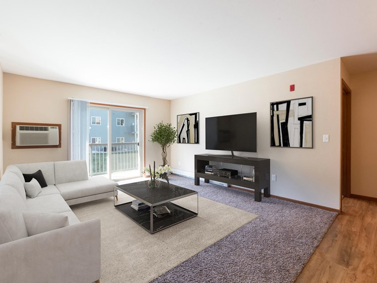 Bismarck, ND Stonefield Apartments. A living room with a modern design and a glass sliding door.
