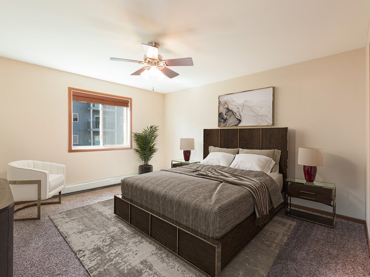 Bismarck, ND Stonefield Apartments. A bedroom with a bed and a ceiling fan