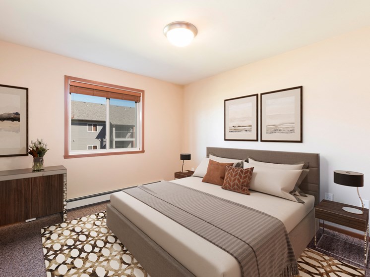 Bismarck, ND Stonefield Apartments. A bedroom with a large bed and two pictures on the wall