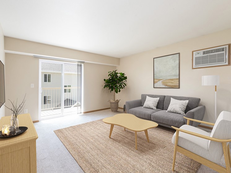 Bismarck, ND Sunset Ridge Apartments. A living room with beige walls and a sliding glass door that leads to a balcony. The room has modern furniture