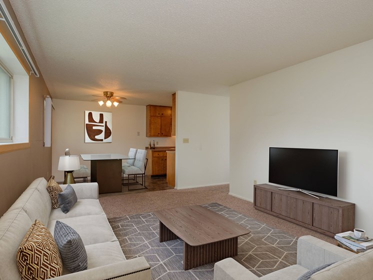 a living room with a couch and a television. Fargo, ND Country Club Apartments