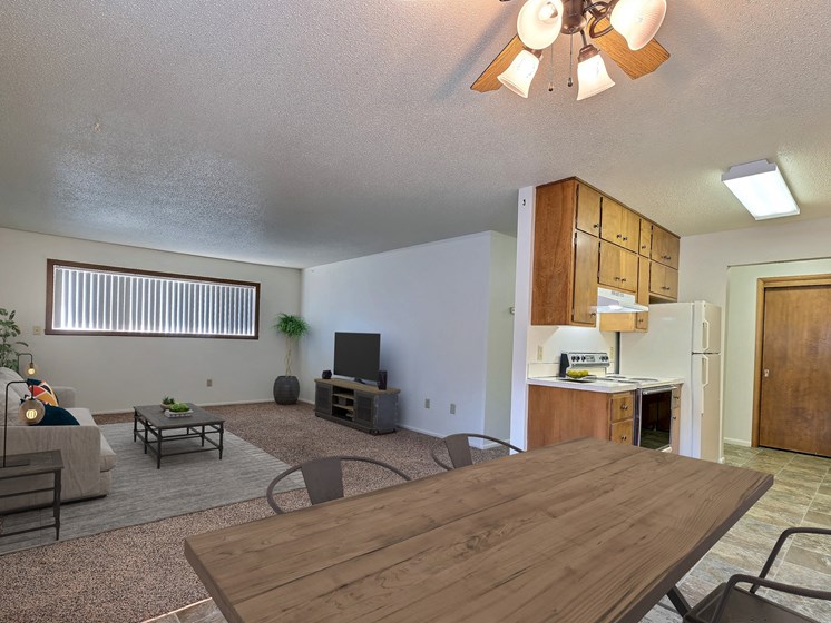 a living room with a wooden table and chairs and a kitchen with a refrigerator and stove. Fargo, ND Emerald Apartments