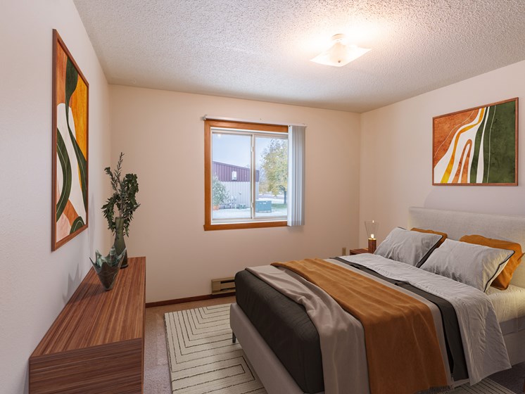 a bedroom with a bed and a window. Fargo, ND Huntington Apartments