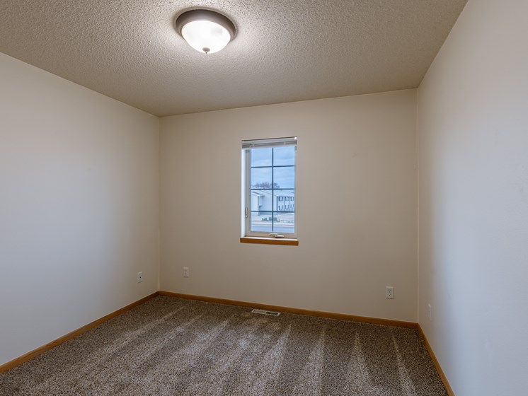 a bedroom with a window. Moorhead, MN Mallard Creek Apartments