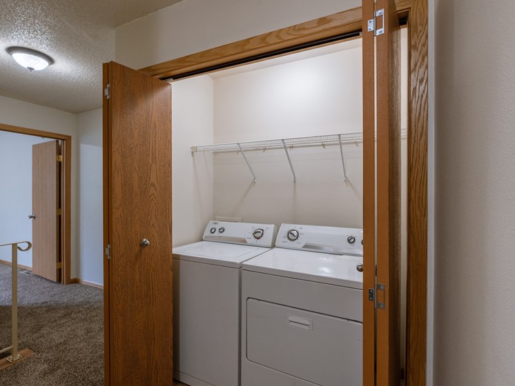 a laundry closet on the second floor of a townhome with a washer and dryer. Moorhead, MN Mallard Creek Apartments