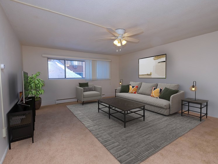 a living room with a couch and a coffee table. Fargo, ND North Manor Apartments