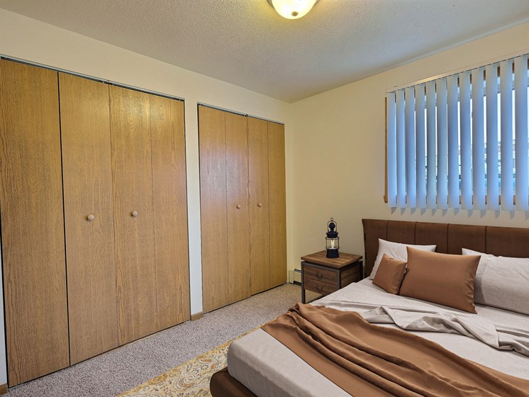 Fargo, ND Saddlebrook Apartments. a bedroom with a bed and two closets