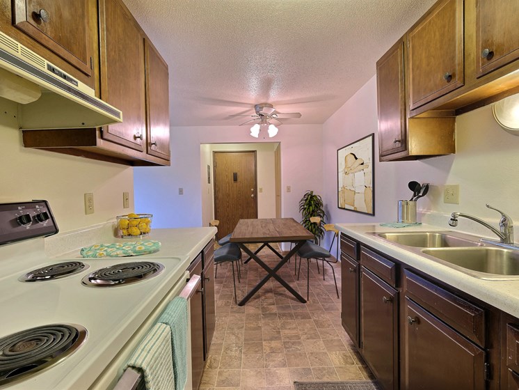 Fargo, ND Saddlebrook Apartments. a kitchen with a stove top oven next to a sink