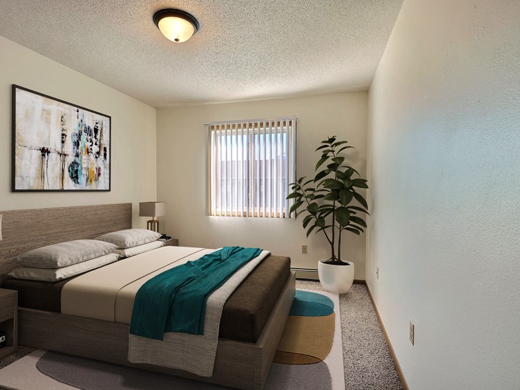 a bedroom with a bed and a potted plant. Fargo, ND Sterling Park Apartments