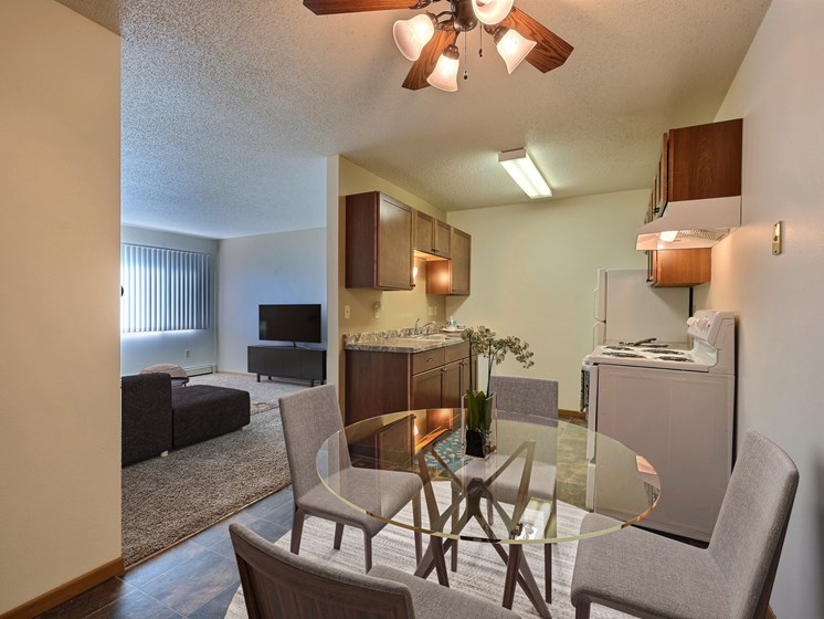 a kitchen and dining room with a glass table and chairs. Fargo, ND Sterling Park Apartments