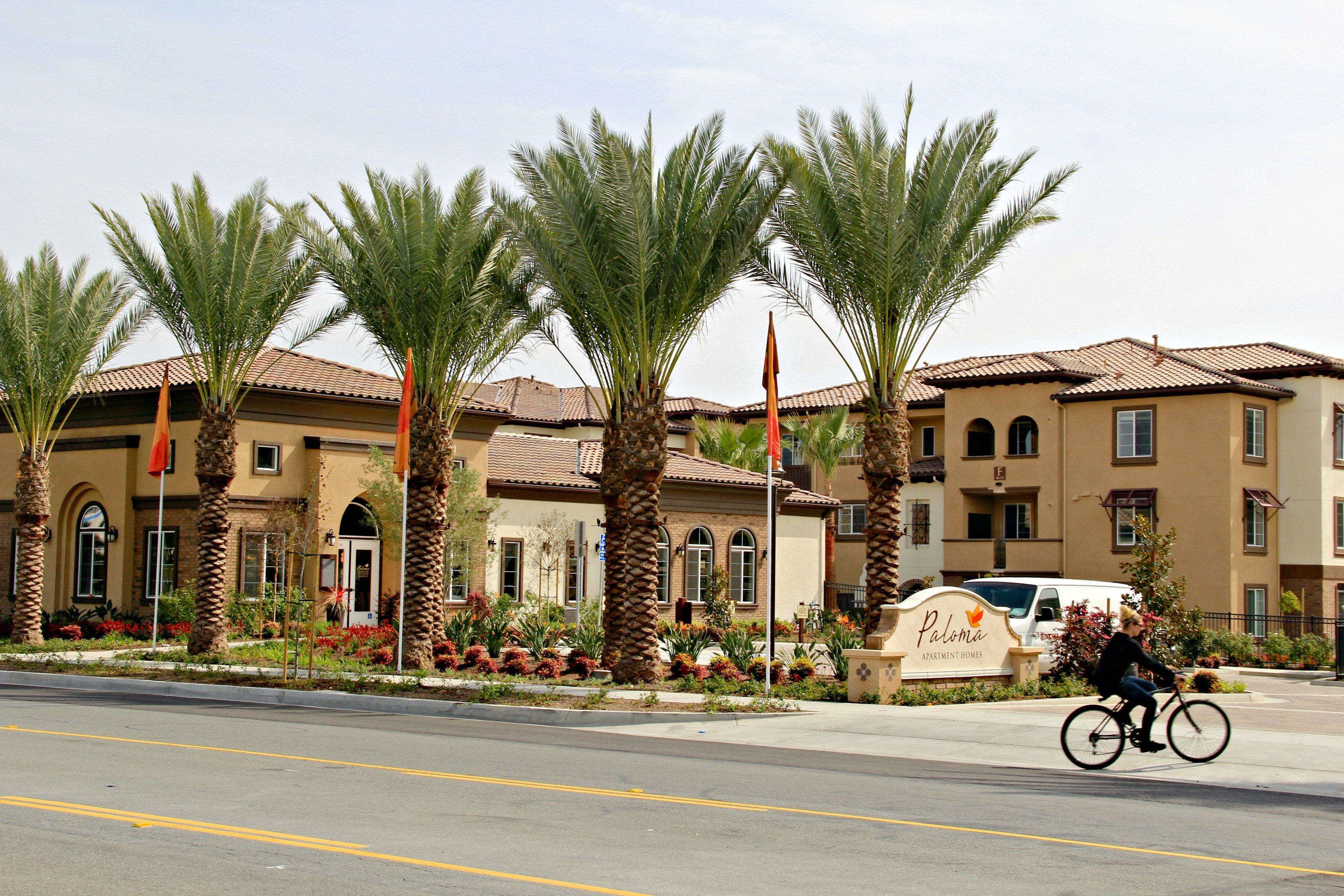 a man riding a bike down a street in front of a building
