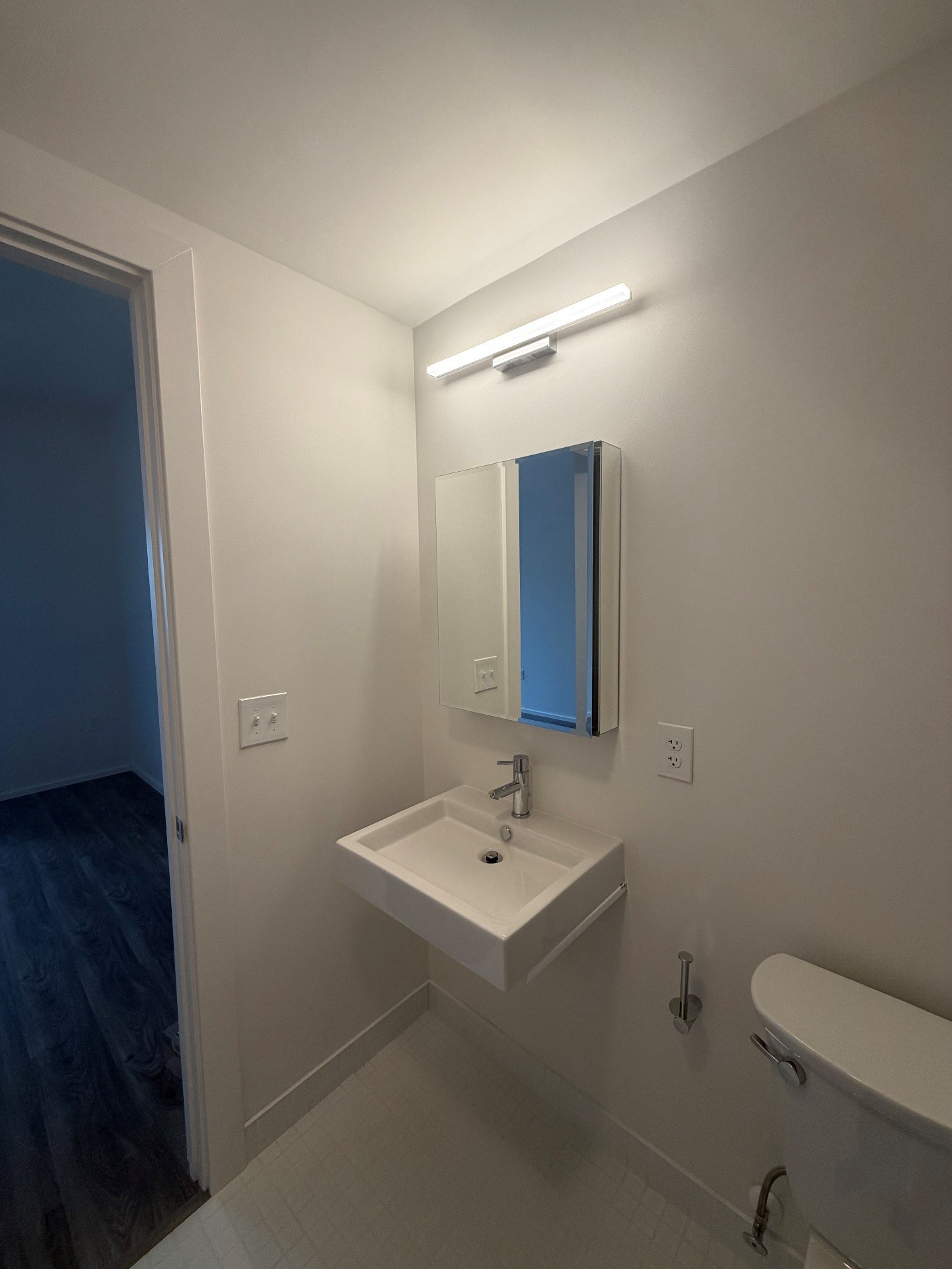 A bathroom with a white sink and a white toilet.