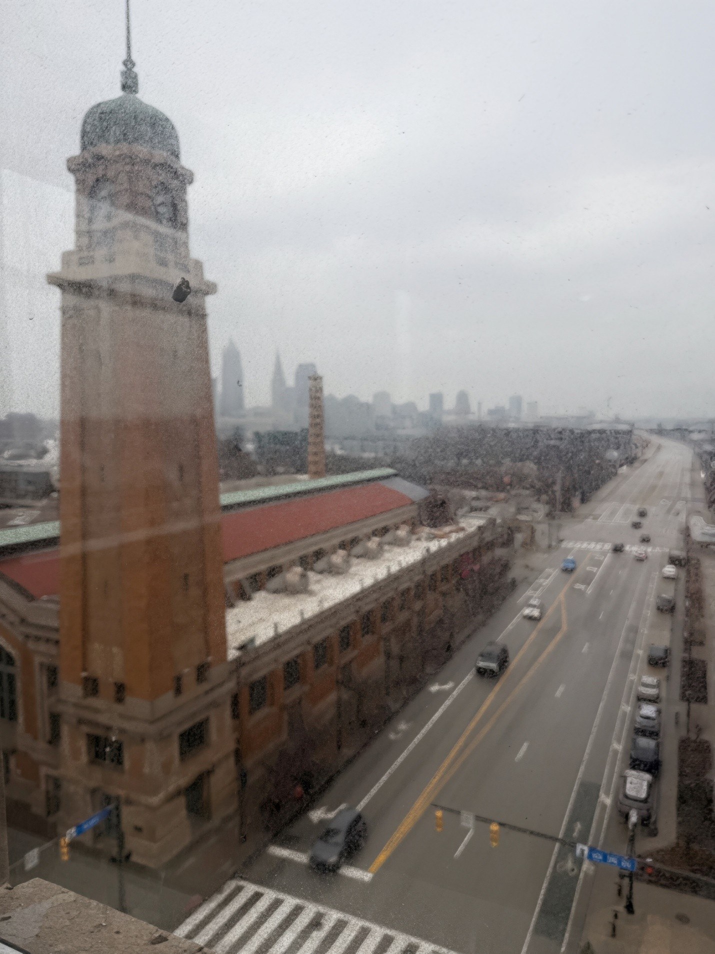 A view of a city street from a high vantage point with a tall building in the background.