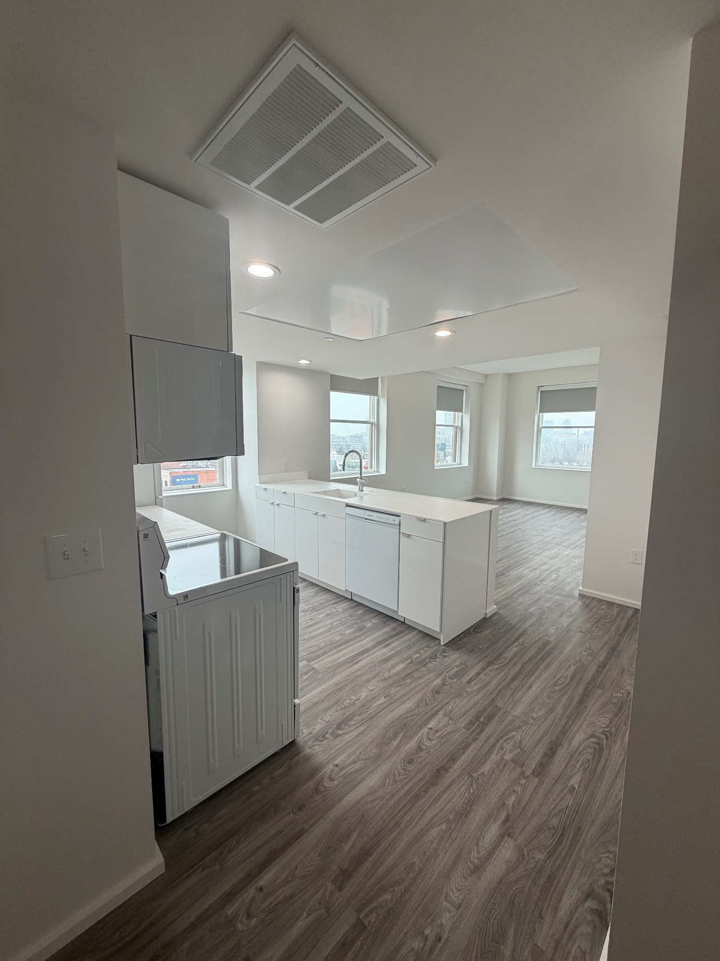 A kitchen with white cabinets and a wooden floor.
