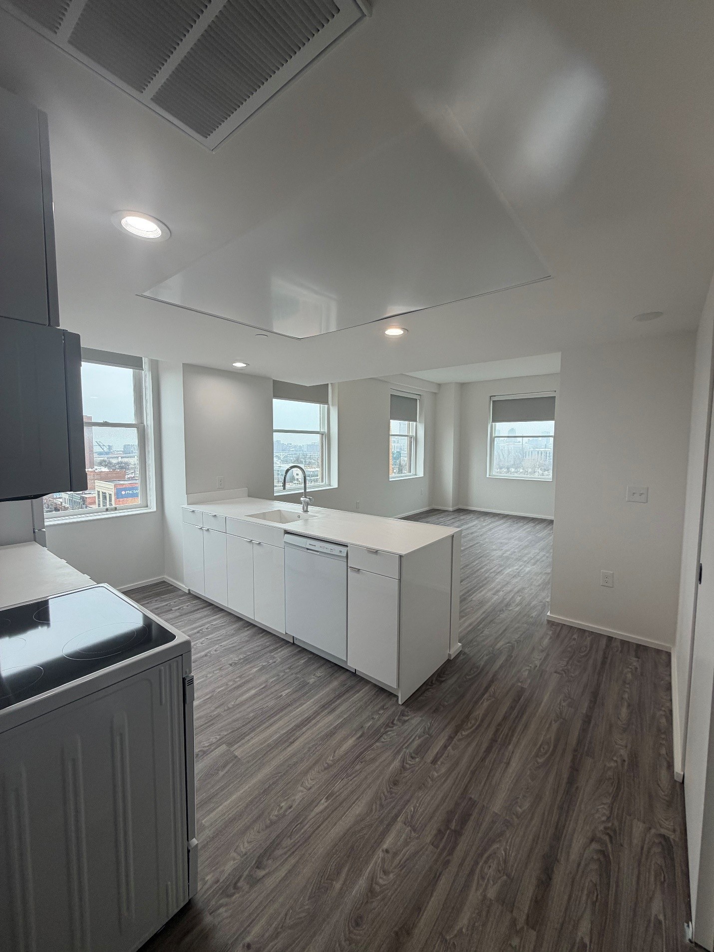 A kitchen with white cabinets and a wooden floor.