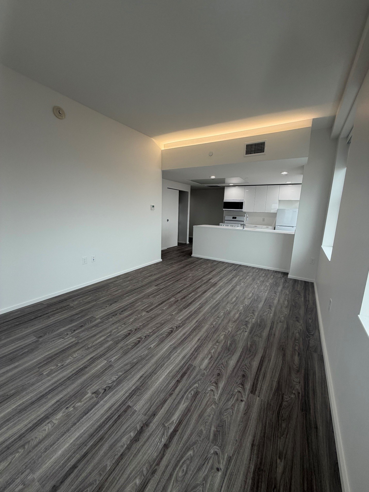 A room with wooden flooring and white walls.