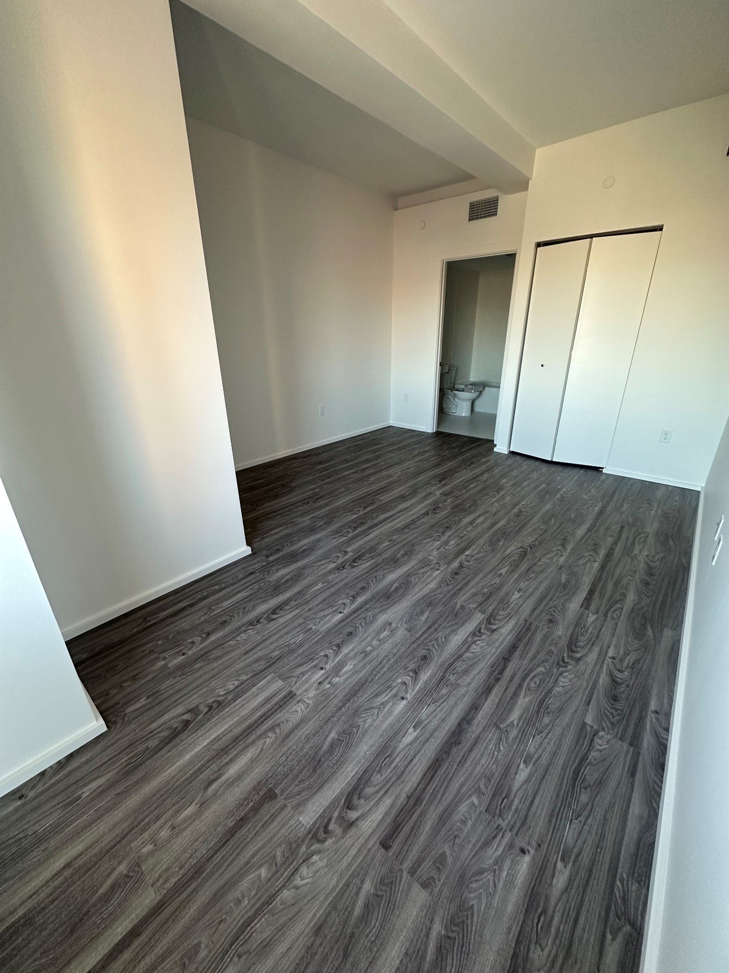 A room with a wood floor and white walls.