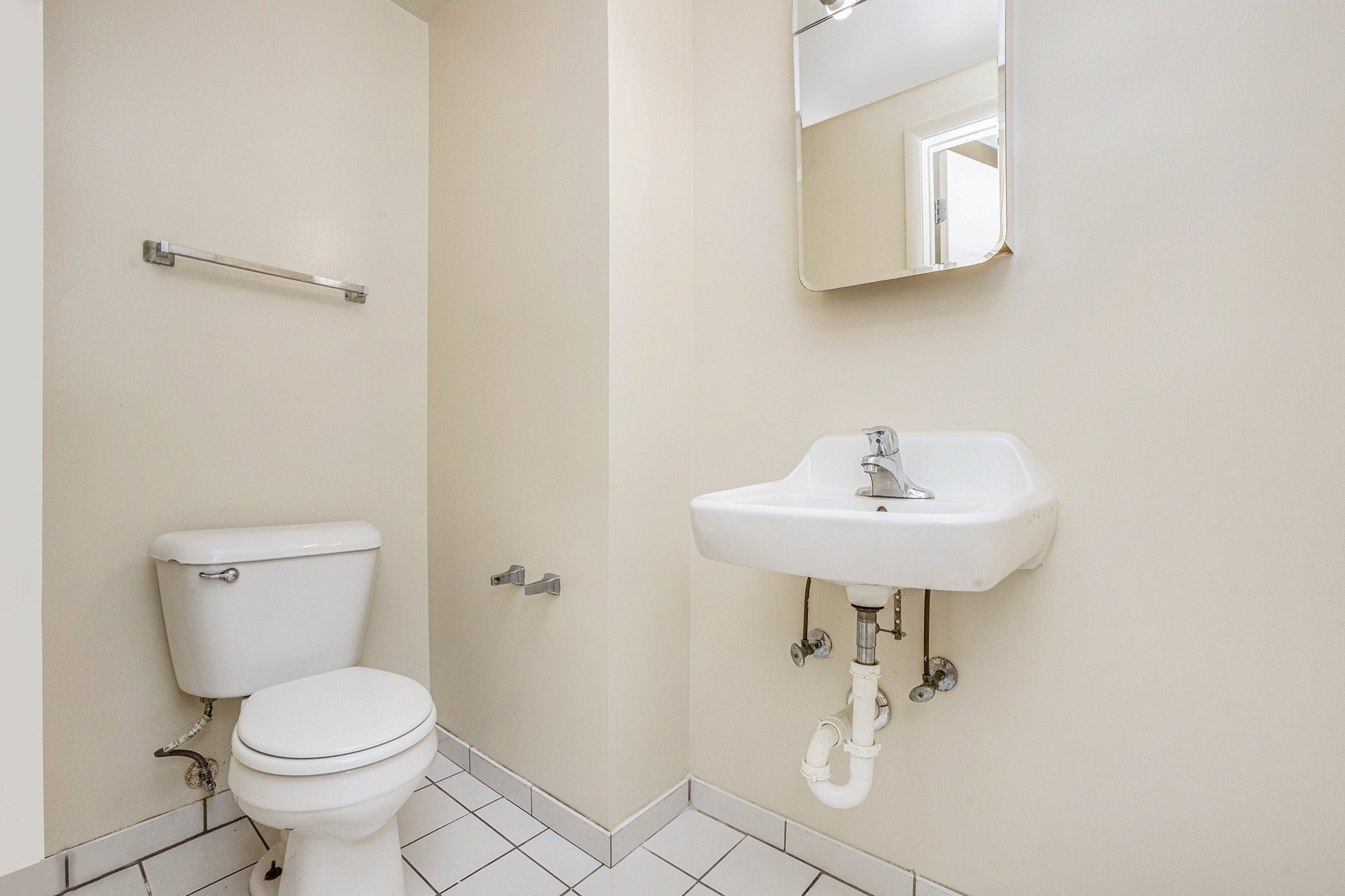 A white toilet and sink in a bathroom.