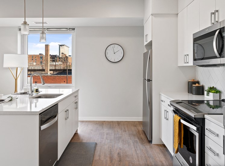 Apartment kitchen with hardwood-style flooring and stainless steel appliances at 23rd Place Apartments in Chicago, IL