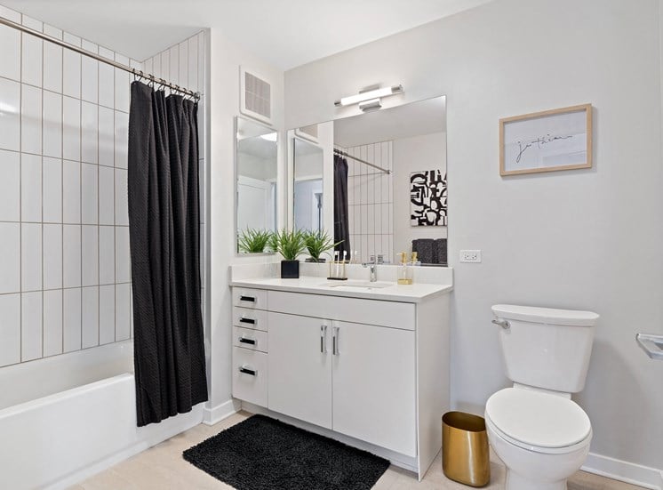 Compact bathroom with bathtub and hardwood style flooring at 23rd Place Apartments