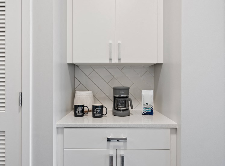 Cozy coffee bar with white cabinet and granite style countertop in studio apartment in Chicago, IL