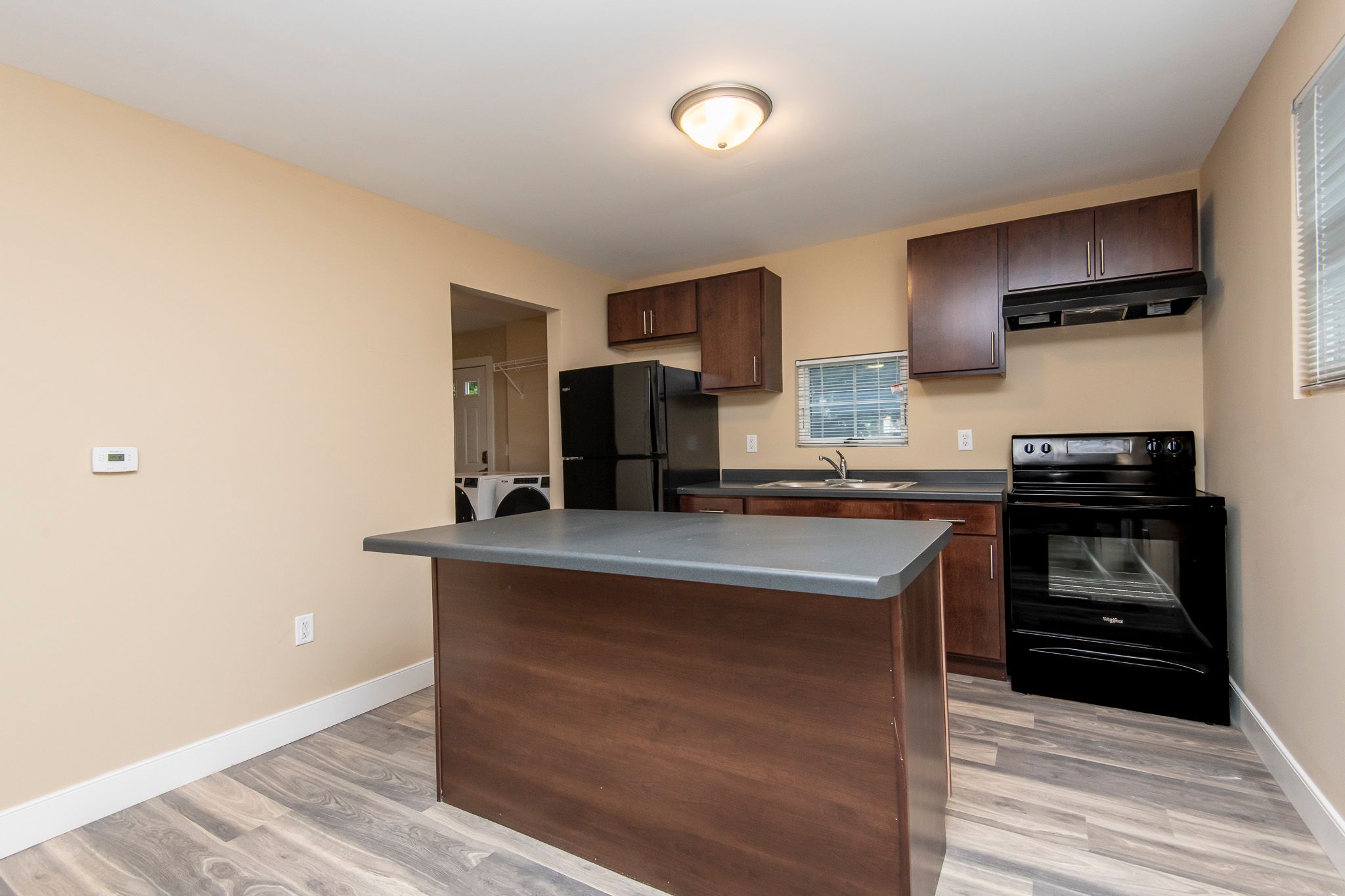 A kitchen with a black refrigerator and stove.