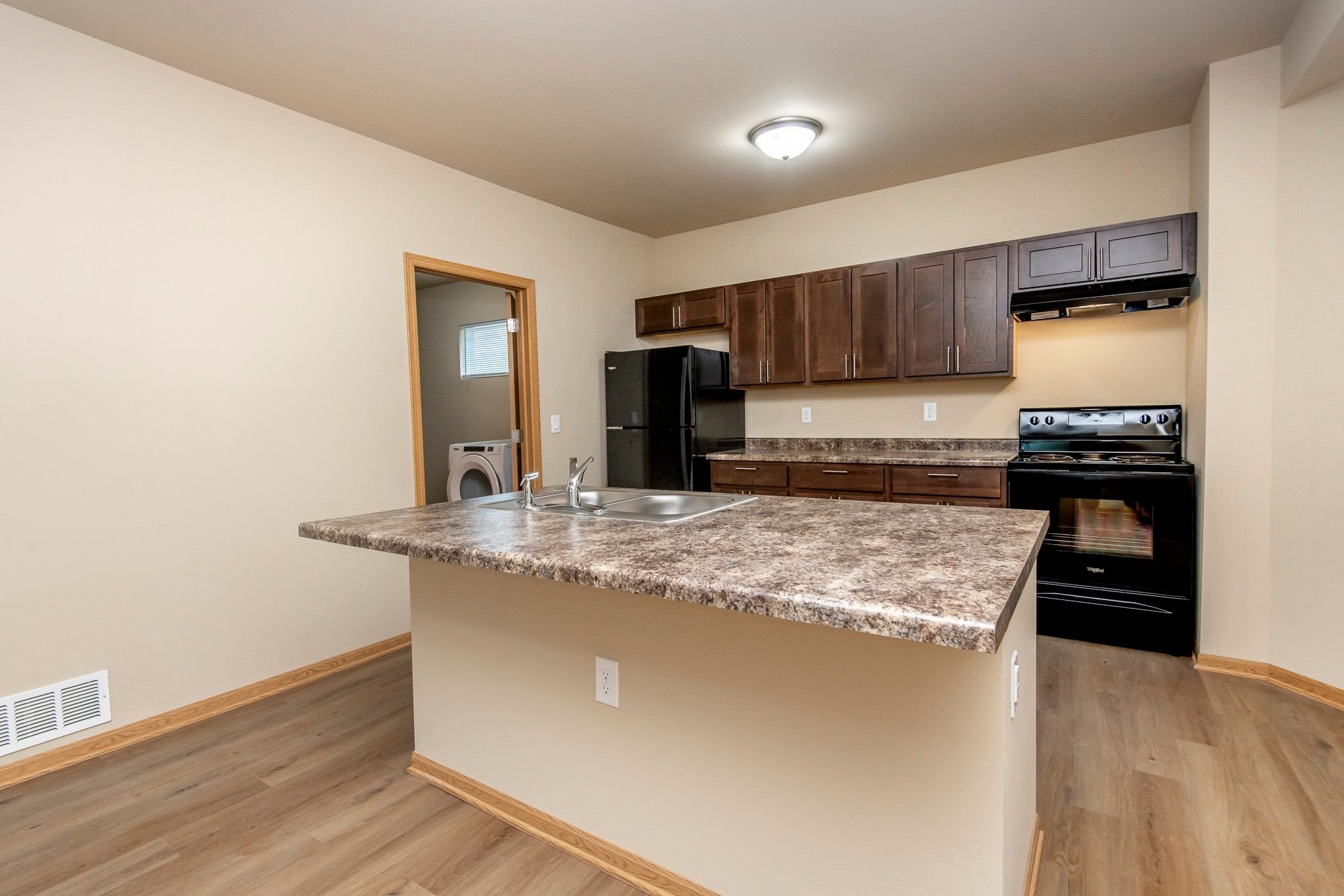 A kitchen with a granite countertop and black appliances.