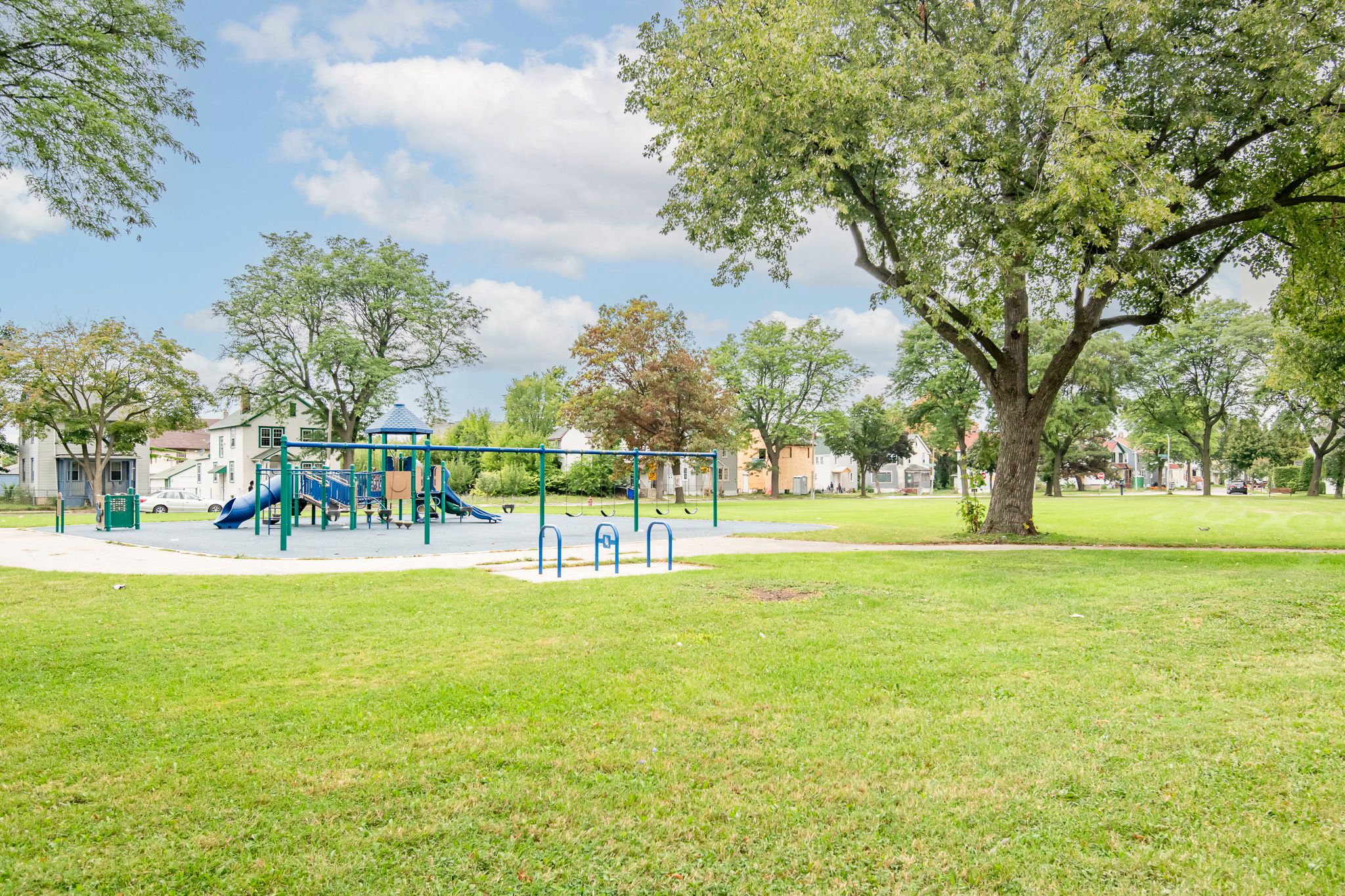 A playground with a green slide and a blue roof.