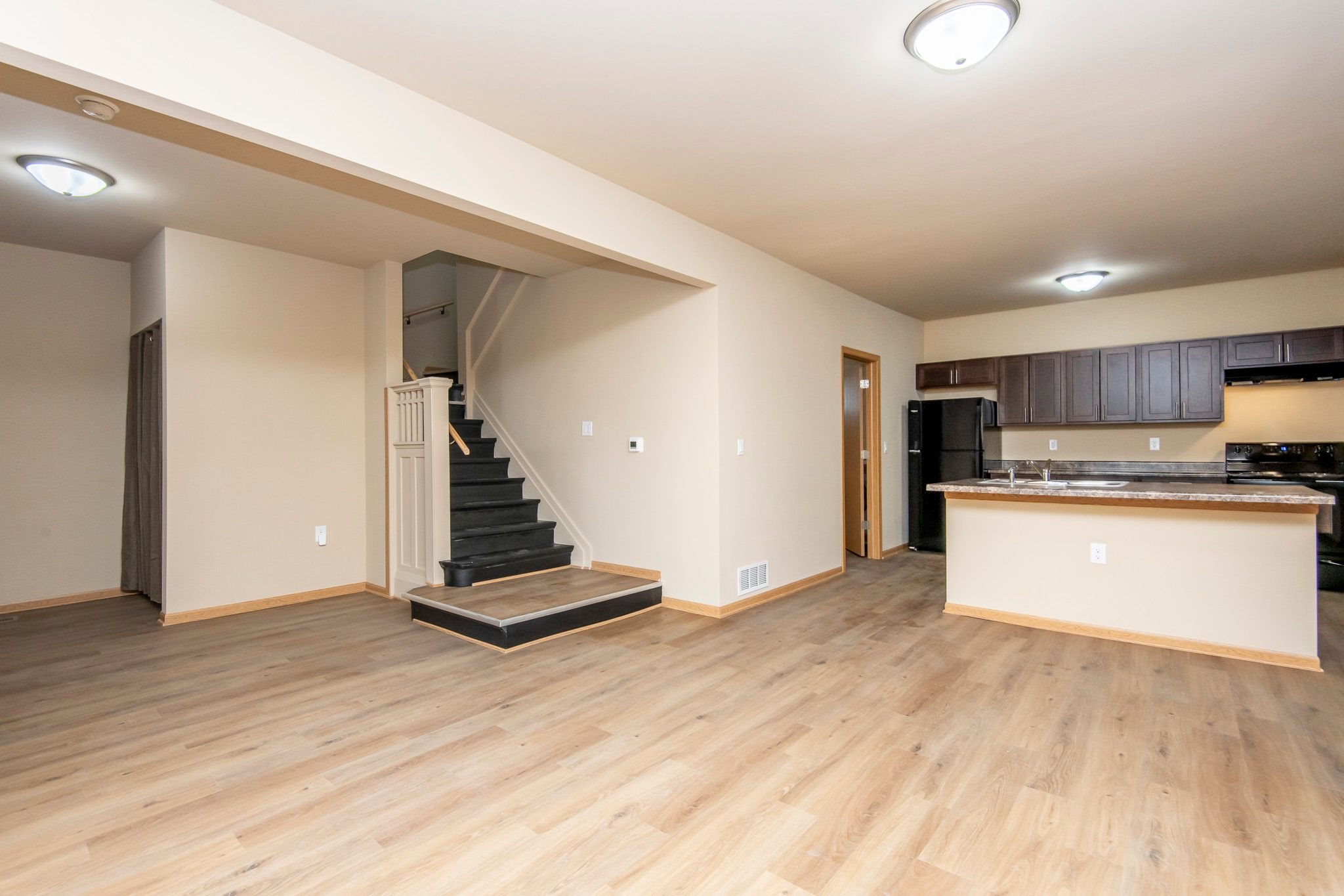 A kitchen with a bar counter and a staircase.