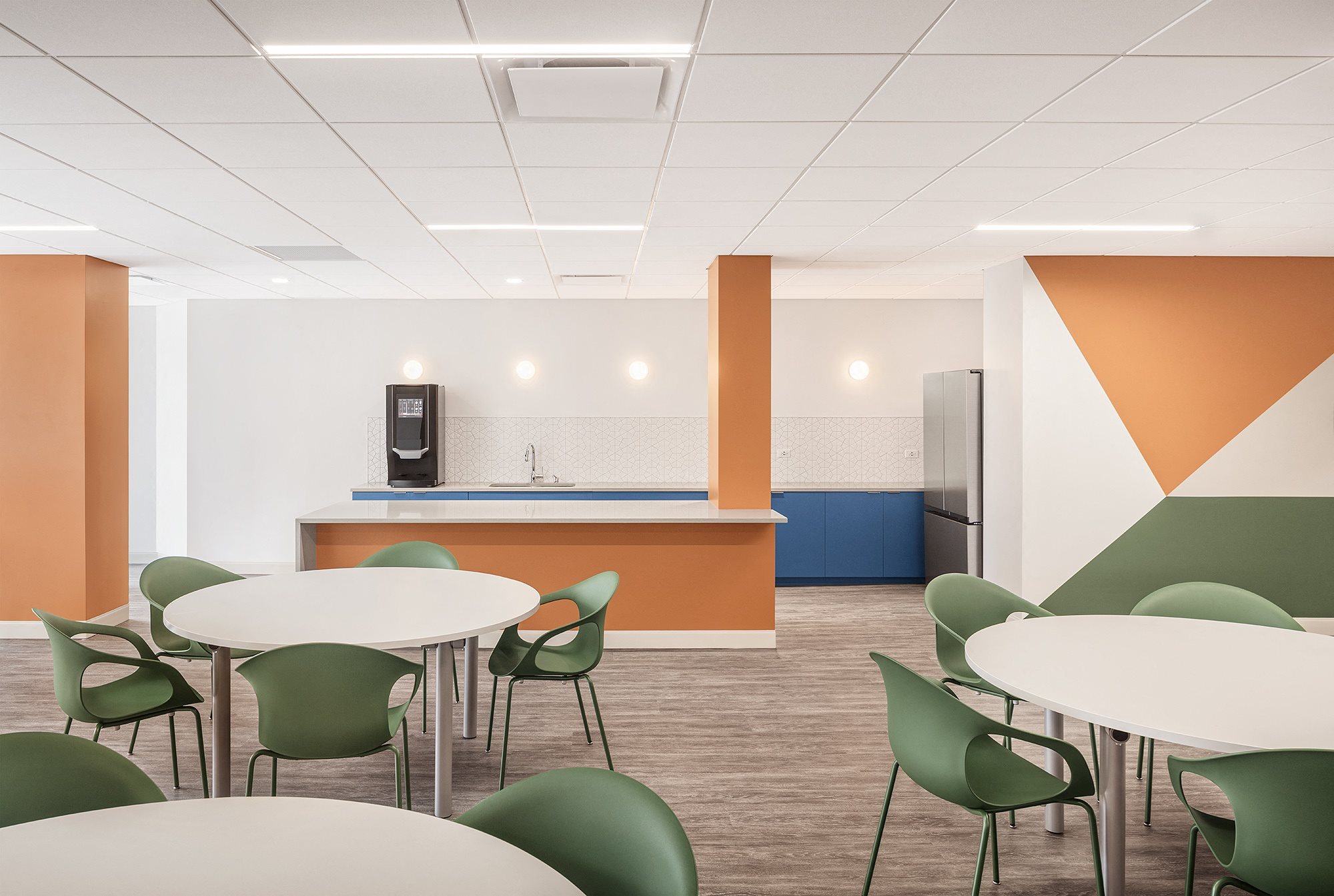 a dining room with tables and chairs and a kitchen