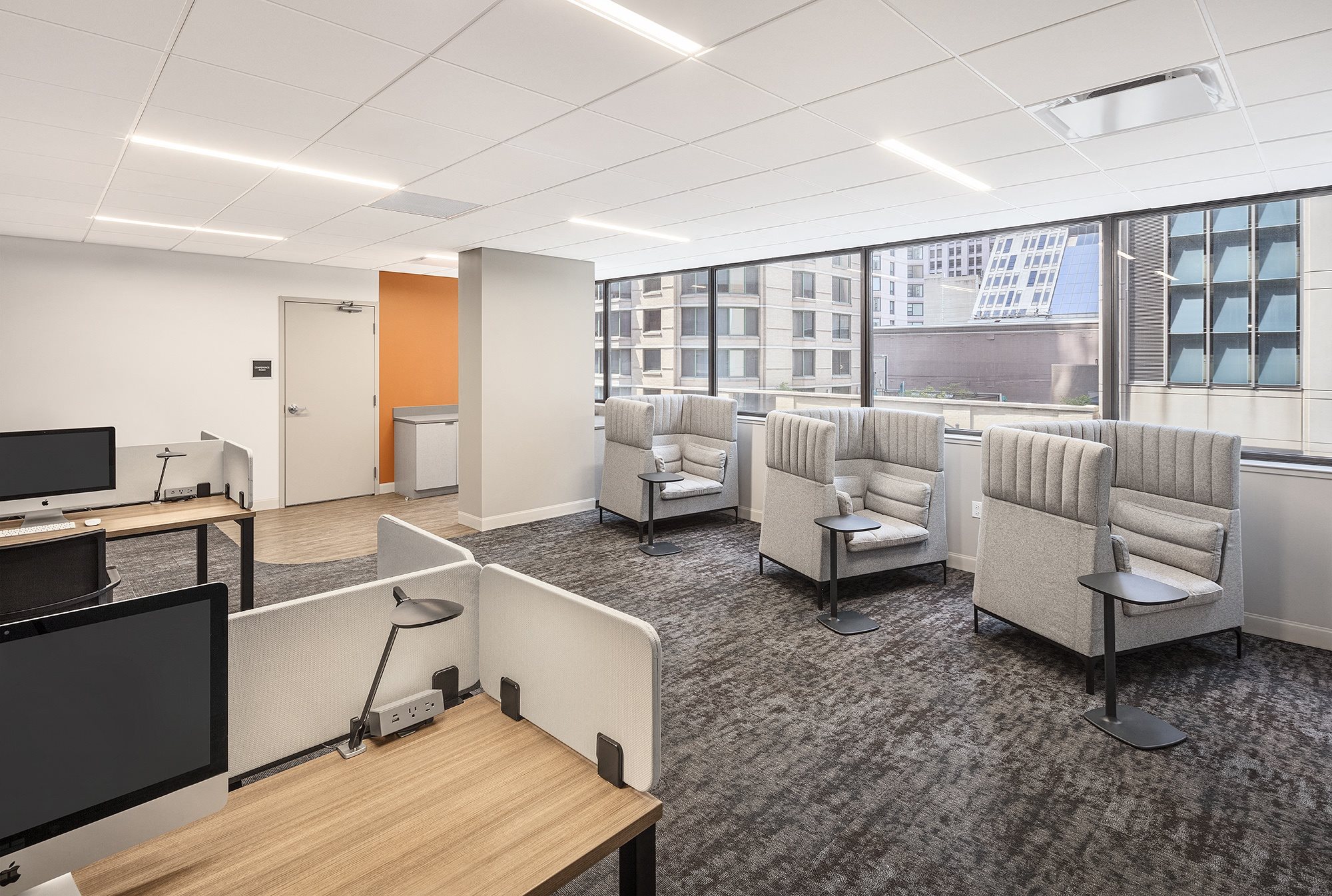 a lounge area with chairs and tables and a tv