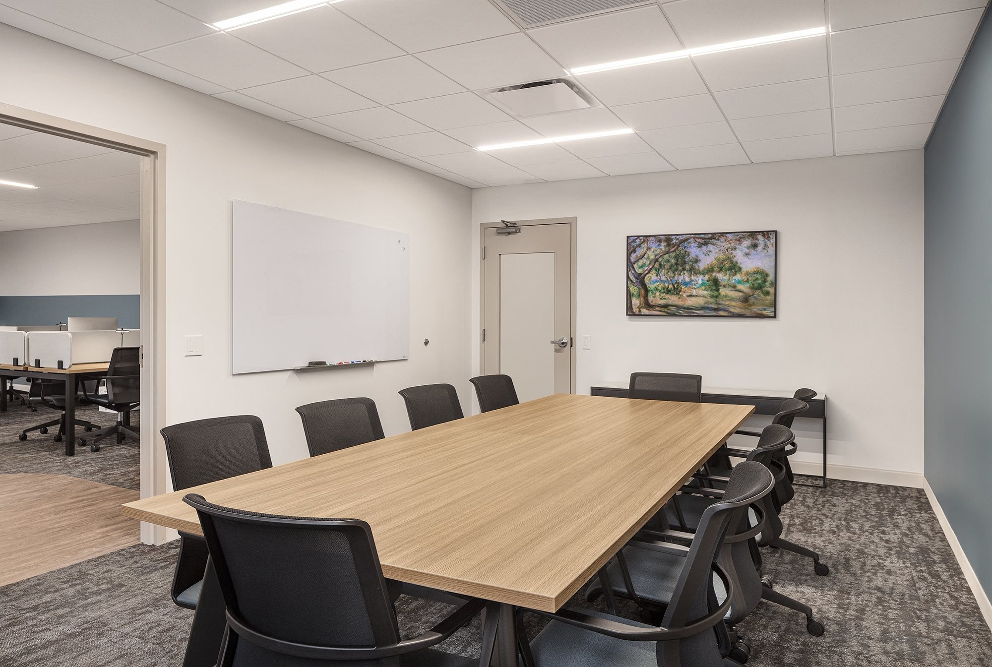 a conference room with a wooden table and black chairs