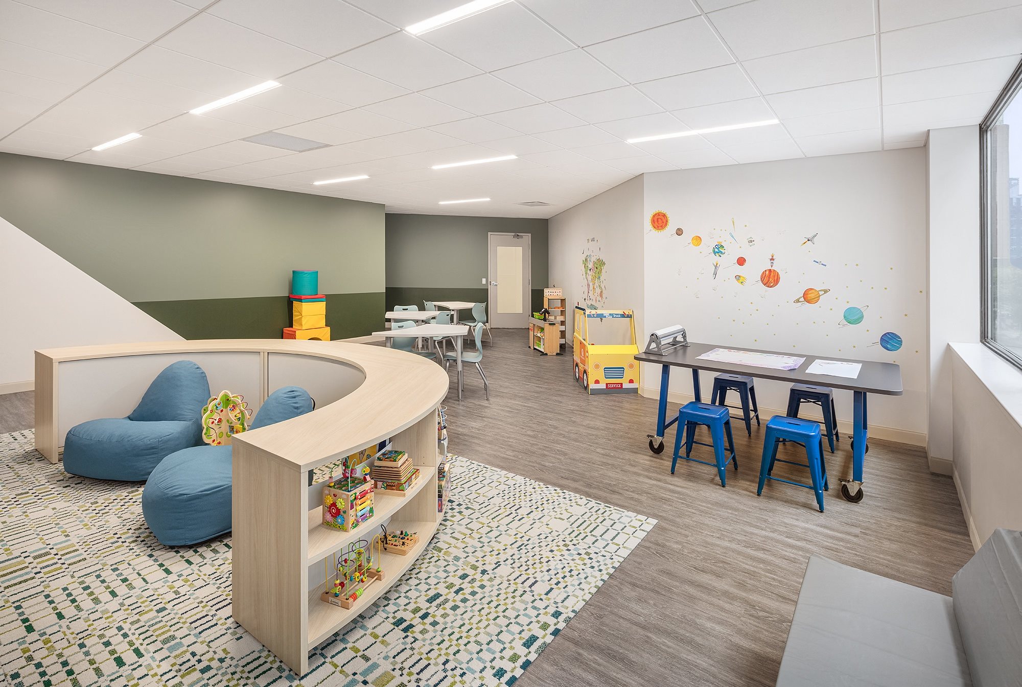 a childrens room with a play area and a table and chairs