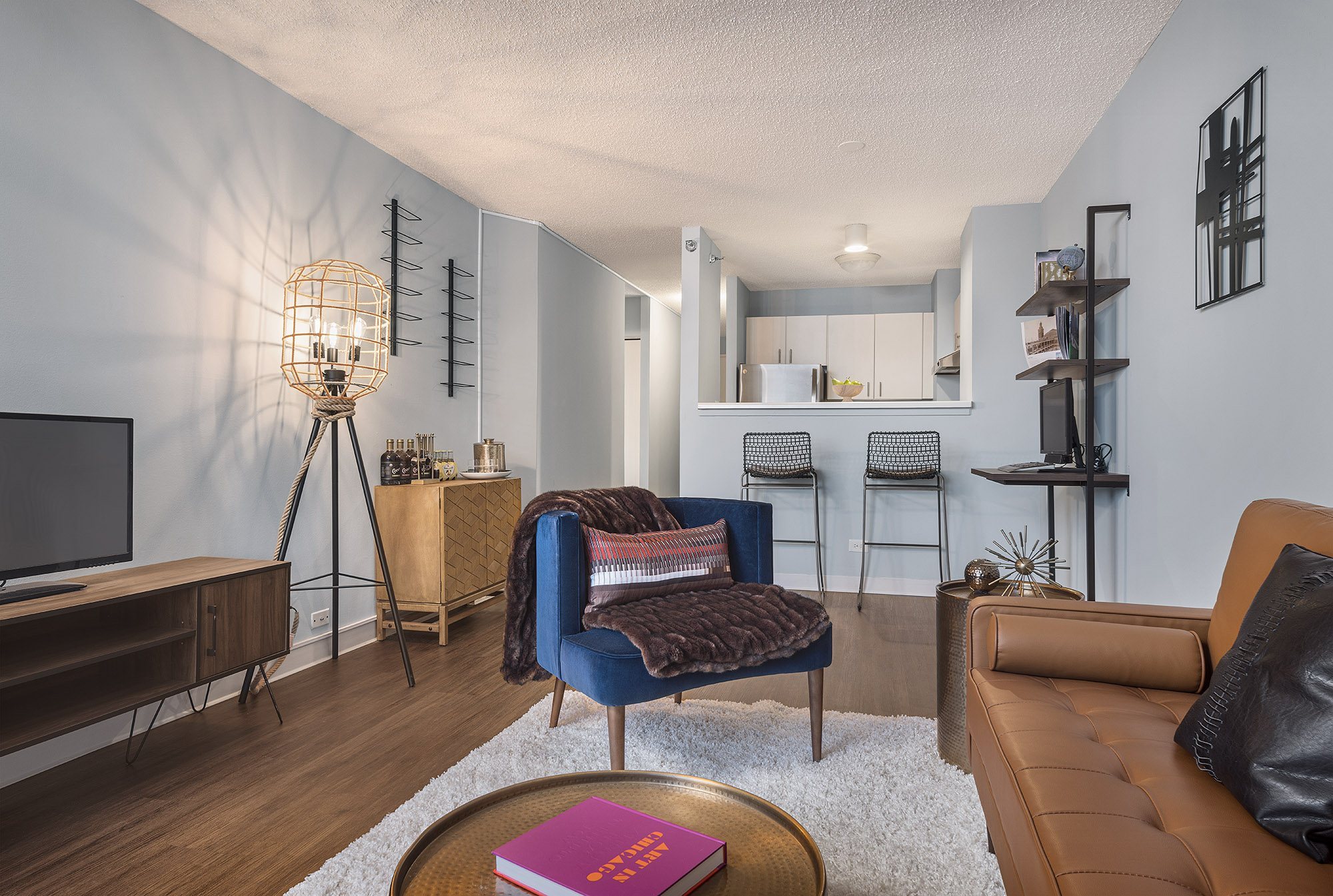 A living room with a blue chair and a brown couch.