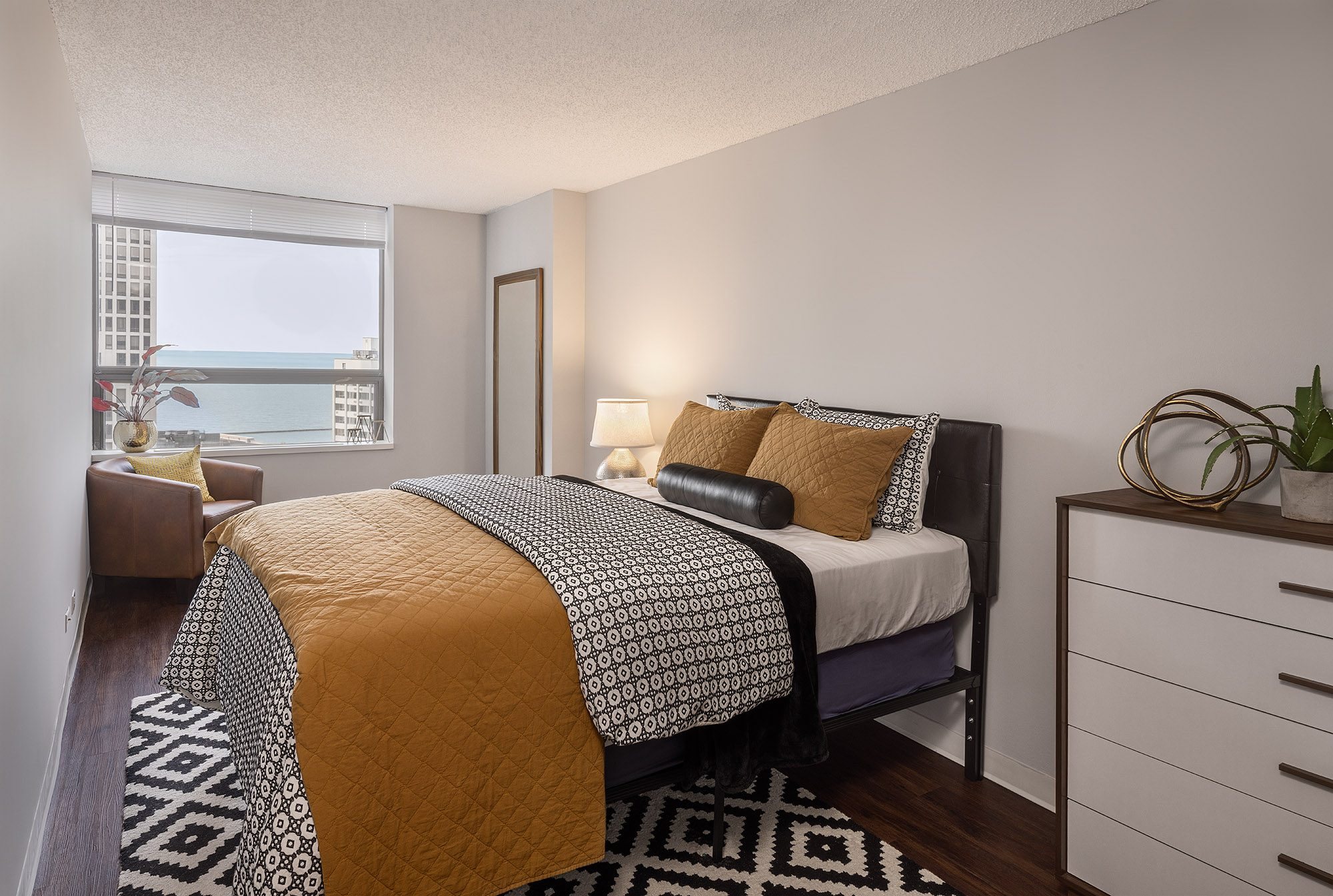 A bedroom with a bed covered in a yellow and black comforter.